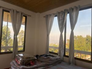 a bedroom with large windows with a bed and a balcony at Bikash Homestay in Mangpu +7 photos