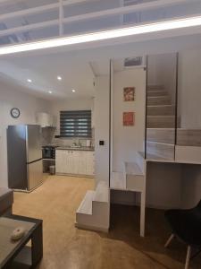 a living room with a staircase and a kitchen at SmallHouseLefkada ΘΕΜΑ in Lefkada