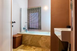 a bathroom with a bath tub and a sink at Room in Historic Knights House at the Marina in Senglea +28 photos