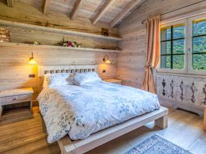 a bedroom with a bed in a wooden room at Chalet Chalet Anna by Interhome in Grosotto