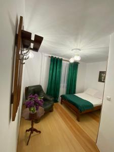 a bedroom with a bed and a chair and green curtains at NOCLEGI NOVA in Krasnobród +17 photos