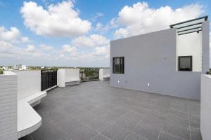 a balcony with white walls and a view of the ocean at Savia Home in Danang