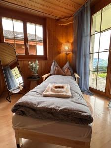 a bedroom with a bed in a room with windows at CapoBnB, Montainview, Terrace in Aeschi bei Spiez