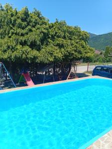 a large swimming pool in front of a house with trees at Vikendica Andrija Drina in Gvozdačko Polje