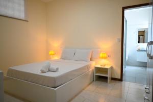 a white bedroom with a bed and a shower at Hotel Rocha in Ribeira Grande