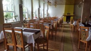 Un restaurante con mesas y sillas en una sala. en Bungalovy Tatranec, en Tatranská Lomnica 6 fotos más