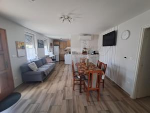 a kitchen and a living room with a table and chairs at Boróka Vendégház Gerjen in Gerjen +13 photos