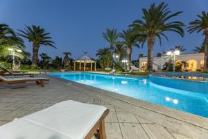 a swimming pool with palm trees in a resort at Villa Oasi di Pace in Nardò