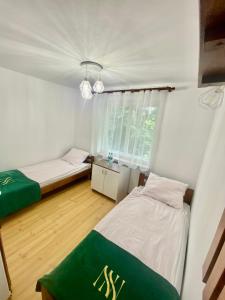 a bedroom with two beds and a window at NOCLEGI NOVA in Krasnobród