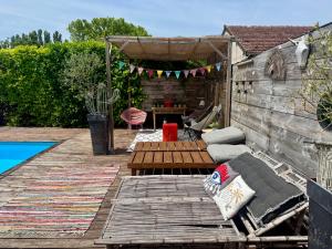 a backyard with a wooden deck with a bench and a table at La Villa d'ElodibiZa, 45mn de Paris en train avec piscine ! in Écuelles +11 photos