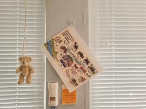 a teddy bear hanging from a window with a book at Ernie MyeongDon'g Sation 1Min, Anytime Check In in Seoul