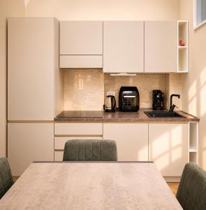 a table and chairs in a kitchen with white cabinets at Donna Teresa Amalficoast in Cetara