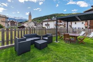 a backyard with a table and chairs and a fence at Giuly's Home Luxury in Bormio