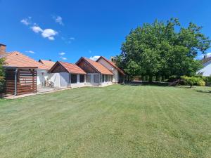 a yard with houses and a large grass field at Vackor Vendégház Gerjen in Gerjen