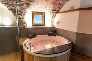 a jacuzzi tub in a room with a window at Giuly's Home Luxury in Bormio +21 photos