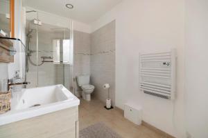 a white bathroom with a sink and a toilet at Studio au Pied de Puycelsi in Puycelci +12 photos