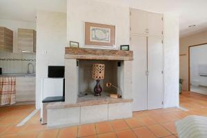 a living room with a stone fireplace with a lamp at Studio au Pied de Puycelsi in Puycelci