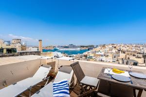 a balcony with a table and chairs and a view of a city at Room in Historic Knights House at the Marina in Senglea