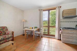 a living room with a table and a kitchen at Studio au Pied de Puycelsi in Puycelci