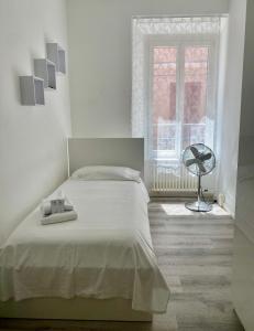 a white bedroom with a bed and a window at Montebello in Bellinzona