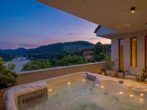 a jacuzzi tub on a balcony with a view at Villa Orso by Interhome in Fužine