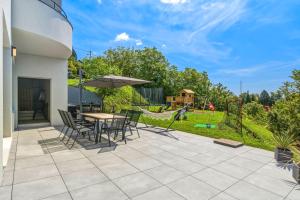 a patio with a table and chairs and an umbrella at Luxury Villa with Indoor Pool and Sauna in Zagreb +114 photos
