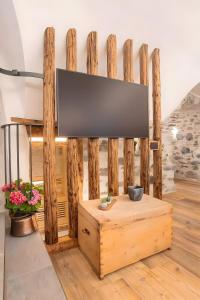 a flat screen tv on a wooden wall in a living room at Giuly's Home Luxury in Bormio