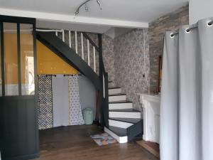 a staircase in a room with a brick wall at L'escapade Guingampaise in Guingamp +8 photos