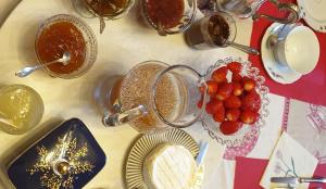 a table topped with plates and bowls of strawberries at Des fleurs au balcon in Quintin