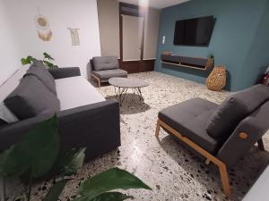 a living room with two couches and a tv at The Forest Villa in Zacharo