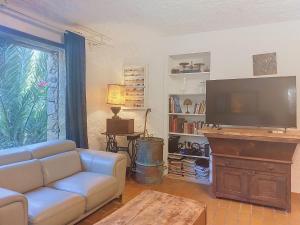 a living room with a couch and a flat screen tv at Holiday Home Posidonie by Interhome in LʼÎle-Rousse +31 photos