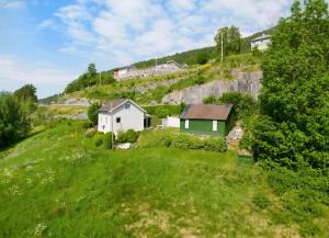 a house on a hill with a green yard at Nordfjord Charm in Stårheim