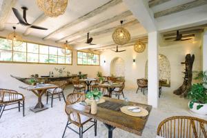a restaurant with tables and chairs in a room at Mala Boutique Hotel in Bwejuu