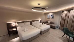ein Hotelzimmer mit zwei Betten und einer Couch in der Unterkunft ASTE hotel in St Julian's