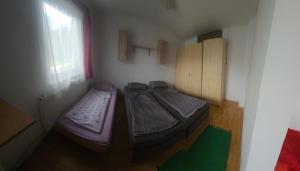 two beds in a small room with a window at Chata pod lesom in Modra