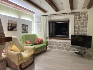 a living room with a green couch and a television at Garden Vista Stone House in Kotor