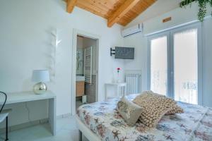 a bedroom with a bed and a desk and windows at Oltremura Rooms Agropoli in Agropoli