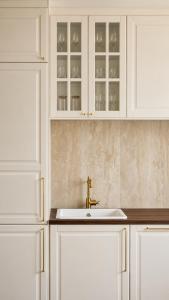 a white kitchen with a sink and white cabinets at Villa Olivia in Banjole +15 photos