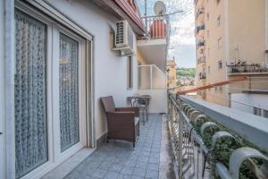 a balcony with chairs and a table on a building at Oltremura Rooms Agropoli in Agropoli