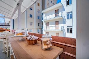 a wooden table on the balcony of a building at Oltremura Rooms Agropoli in Agropoli