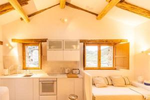 a kitchen with white cabinets and a counter top at La Cueva Rural Boutique Villa in La Focella