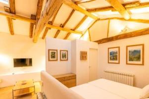 a living room with a white couch and a tv at La Cueva Rural Boutique Villa in La Focella