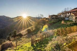 a sun is shining on a hill with a rainbow at La Cueva Rural Boutique Villa in La Focella