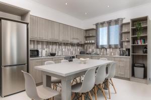 a kitchen with a white table and white chairs at Villa Vibella in Laganas