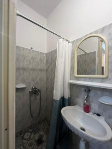 a bathroom with a sink and a shower with a mirror at Armonia Studio in Paralia Katerinis
