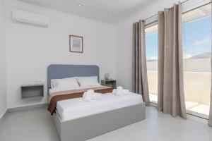 a bedroom with a bed and a large window at Villa Vibella in Laganas