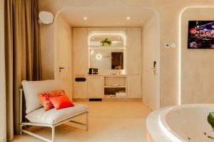 a bathroom with a white tub and a chair and a bath tub at Boutique Hotel Charley's in Westkapelle