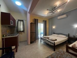 a bedroom with a bed and a kitchen with a sink at Armonia Studio in Paralia Katerinis
