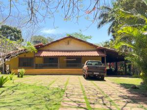 a truck parked in front of a yellow house at Rancho Dias Mágicos in Uberlândia