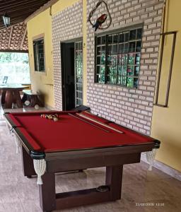 a red pool table in front of a building at Rancho Dias Mágicos in Uberlândia